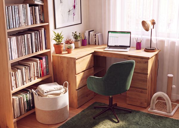 Ufficio in casa con scrivania angolare in legno, sedia da ufficio ergonomica verde, laptop, libreria, lampada da scrivania e piante da interno, per creare uno spazio di lavoro comodo e produttivo per lavorare da casa.