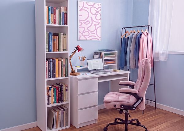 Spazio studio moderno per studenti con scrivania bianca, sedia da ufficio ergonomica, laptop, libreria, mobile contenitore e appendiabiti, in una camera da letto luminosa e ordinata pensata per studiare comodi e vivere al meglio la vita di tutti i giorni.