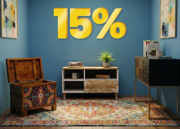 Banner pubblicitario con uno sconto del "15%" in grandi numeri gialli 3D sopra un ambiente moderno con tappeto a motivi, cassapanca e madia su pareti blu. Clicca per vedere i prodotti della collezione.