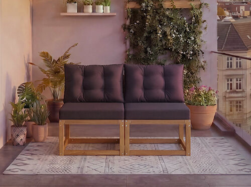 Divano modulare in legno a due posti con cuscini grigio scuro su un balcone circondato da piante in vaso e vista sulla citt&agrave; sullo sfondo