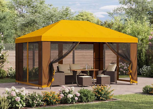 Gazebo da giardino giallo con tende a rete che ripara un salottino con tavolo su un patio, circondato da piante fiorite in un giardino soleggiato.