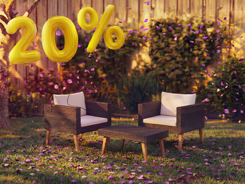 Poltrone lounge da esterno in rattan con cuscini e un tavolino in un&rsquo;ambientazione da giardino, decorate con coriandoli rosa e palloncini dorati con &laquo;20% di sconto&raquo;, che mettono in evidenza offerte stagionali sui mobili lounge da giardino.