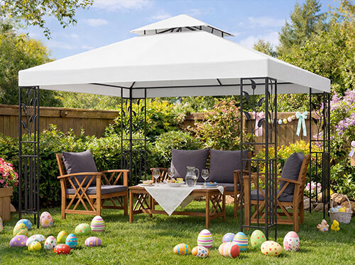 Set di mobili da giardino sotto un gazebo bianco, con sedie e tavolo in legno per una riunione di Pasqua, uova di Pasqua colorate sul prato verde, fiori in fiore e decorazioni primaverili in giardino soleggiato.