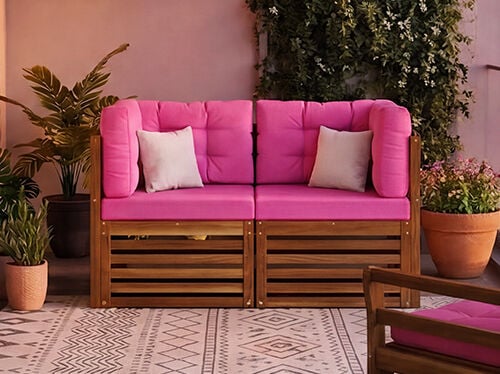 Nuovo set divano modulare da balcone con cuscini rosa vivaci e struttura in legno massiccio, allestito su un balcone urbano con piante e ringhiera in vetro, badge NEW visualizzato