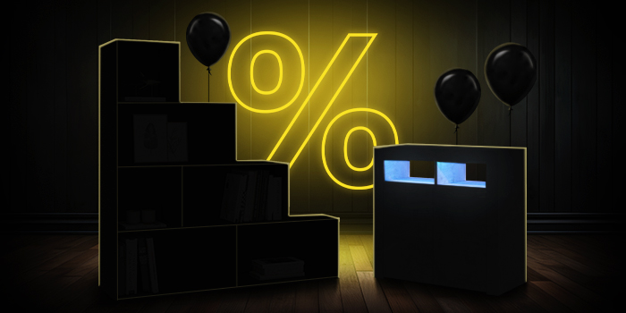  Mobili contenitori modulari neri con palloncini neri davanti a un cartello giallo luminoso con il simbolo della percentuale su un pavimento di legno scuro.