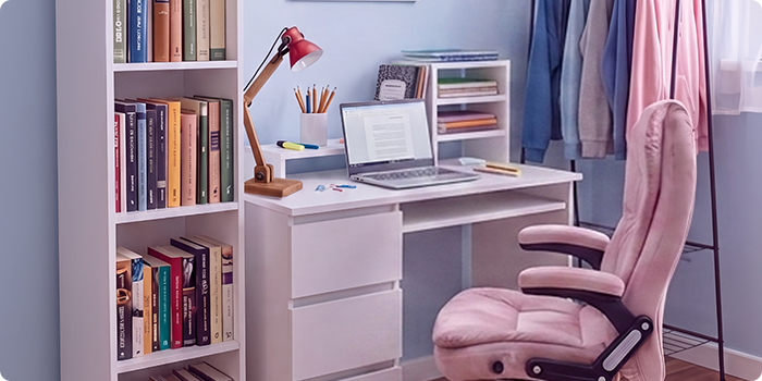 Spazio studio moderno per studenti con scrivania bianca, sedia da ufficio ergonomica, laptop, libreria, mobile contenitore e appendiabiti, in una camera da letto luminosa e ordinata pensata per studiare comodi e vivere al meglio la vita di tutti i giorni.
