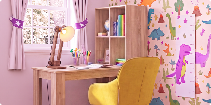 Stanza studio luminosa per bambini con scrivania in legno, sedia ergonomica gialla, lampada da scrivania, scaffale contenitore e carta da parati con dinosauri, ideale per creare in casa uno spazio ordinato e comodo per imparare.
