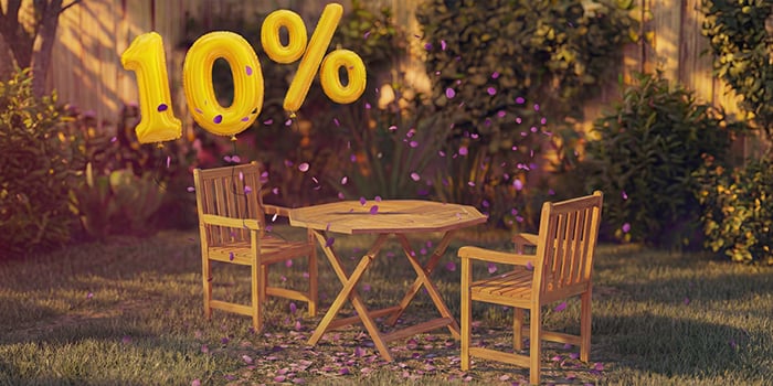  Tavolo da pranzo da esterno in legno con due sedie abbinate in un’ambientazione da giardino, decorato con coriandoli rosa e palloncini dorati con «10% di sconto», che mette in evidenza una promozione stagionale sui mobili da pranzo per esterni.