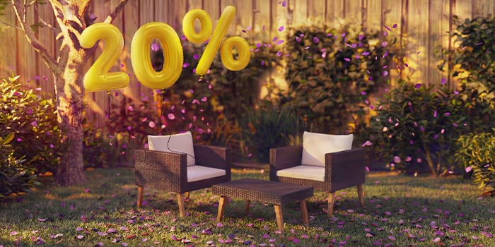  Poltrone lounge da esterno in rattan con cuscini e un tavolino in un’ambientazione da giardino, decorate con coriandoli rosa e palloncini dorati con «20% di sconto», che mettono in evidenza offerte stagionali sui mobili lounge da giardino.